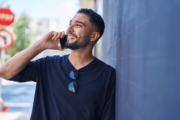 Young arab man smiling confident talking on the smartphone at street