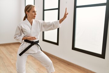 Young caucasian woman training karate at sport center