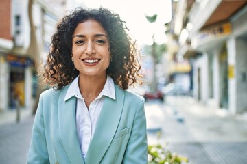Young hispanic business woman wearing professional look smiling confident at the city - obrazy, fototapety, plakaty