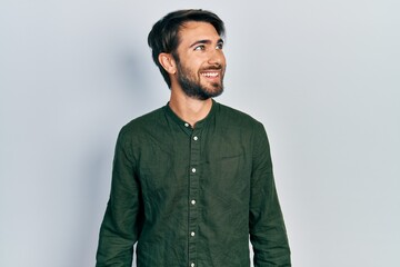 Young hispanic man wearing casual clothes looking to side, relax profile pose with natural face and confident smile.