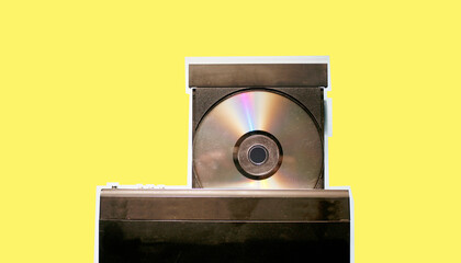Flatlay view of dirty dvd player with disk isolated on yellow pastel background
