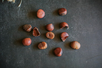 Chestnuts on dark grey background. Pile of fresh chestnuts ready to roast. Top view, copy space. Flat lay. Space for text