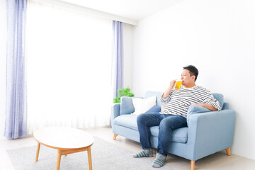 Obraz premium Middle-aged man drinking beer at home