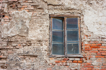 Fototapeta na wymiar Wood framed window is open with glass on a worn brick and plaster historic building in Osijek, Croatia.