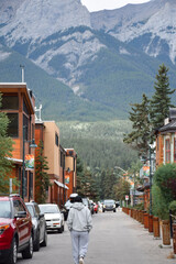 Young girl from behind walking on small street in the town of Banff