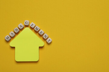 Word Management made of wooden cubes near arrow shaped paper note on yellow background, flat lay. Space for text