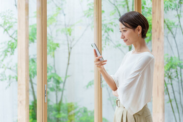 リビングでスマートフォンを使う若い女性