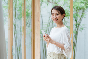 リビングでスマートフォンを使う若い女性