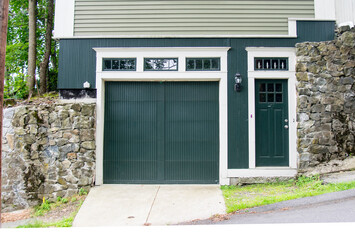 One car Garage Door with additional Door entrance, both painted in black color