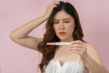 stessed pregnant woman holding and showing the positive pregnancy test