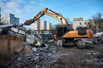 Fototapeta premium Excavator with hydraulic scissors cuts concrete beams