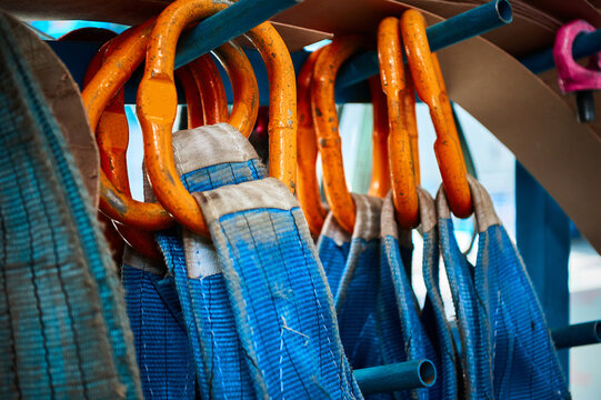 Rigging equipment with textile strops hangs on rack hooks