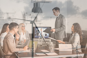 Double exposure of business people during meeting in office and windmill for electric power...