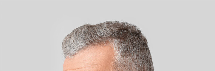 Senior man with grey hair on light background, closeup