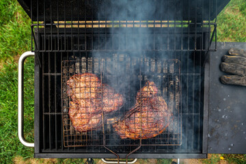 food, craft and delicious concept - cooking T-bone steak on a grill. High quality photo