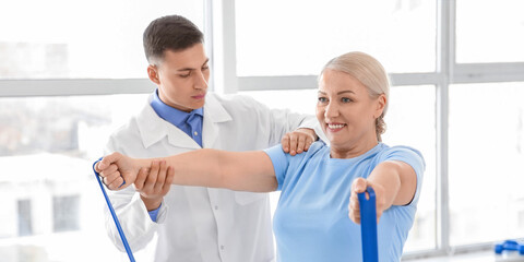 Obraz premium Physiotherapist working with mature patient in rehabilitation center