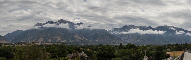 Fototapeta na wymiar Panorama of the Wasatch mountains as seen from Sandy Utah, with low clouds.