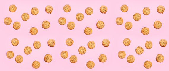 Tasty peanut cookies on pink background, top view
