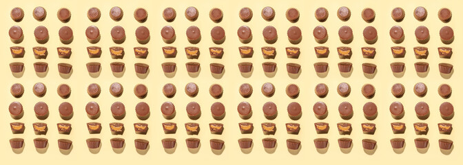 Tasty peanut butter cups on light background, top view