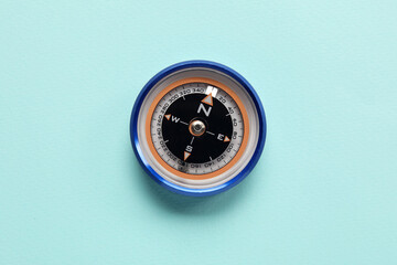 Tourist's compass on light blue background