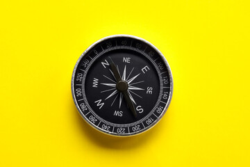 Tourist's compass on yellow background