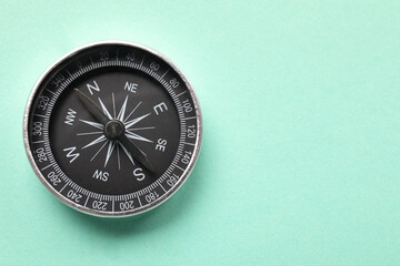 Tourist's compass on turquoise background