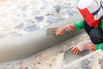 Worker plasterer mortar edge of sidewalk.
