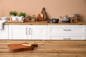 Fototapeta na wymiar Cutting board with knife on table in kitchen