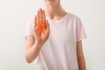 Woman with orange awareness ribbon on white background. Kidney cancer concept