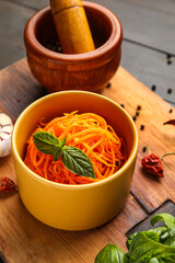 Bowl with carrot salad and ingredients on wooden board