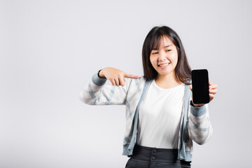Woman excited pointing finger to a smartphone screen studio shot isolated white background, happy young female smiling showing something product on mobile phone screen