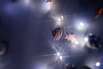 a garland of cones with lights in blue tones on a dark background. selective focus