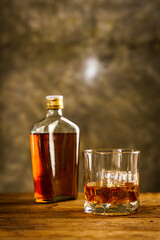 Wiskey in a glass with the ice cubes on the reflective black surface. Bar drinking menu