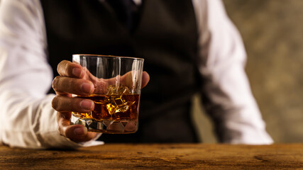 Barman pouring wiskey whiskey glass and giving.