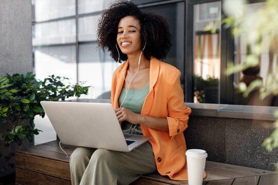afro woman using laptop outdoor