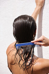 Hair Beauty. Closeup Of Woman Hairbrushing With Comb And Using Conditioner. Young Female Model Putting Mask On Long Wet Hair 