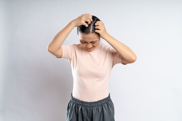 Asian woman scratching her head, standing isolated on white background.