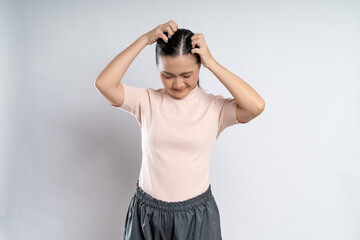 Asian woman scratching her head, standing isolated on white background.