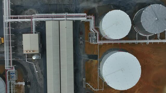 Industrial factory with pipeline to chemical storage tanks. Aerial top down. Factory location in USA.