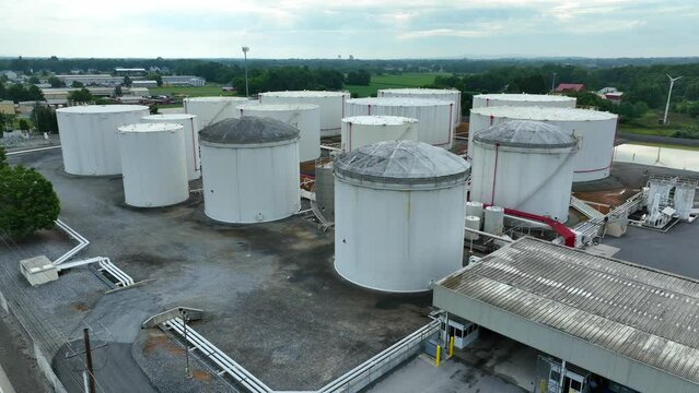 Fuel trucks at oil gas terminal with bulk storage tanks. Energy distribution in USA theme.