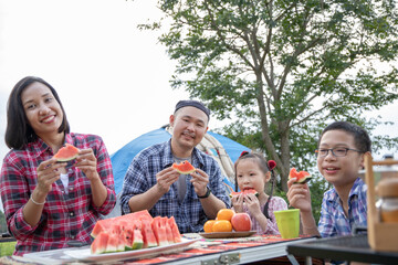 Happy asian family  feel happy while eating water melon at a picnic