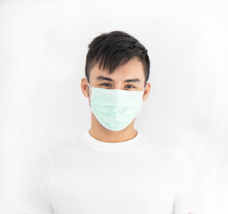 Asian handsome man wearing surgical mask standing overwhite background