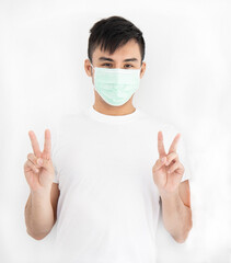 Asian handsome man wearing surgical mask standing overwhite background