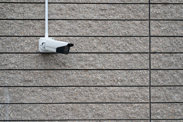 Security camera on dark modern building, technology concept. CCTV Camera on concrete wall