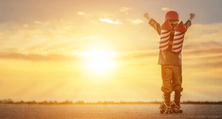 Little boy in a rocketman costume on roller skates at sunset. Ñhild imagines himself as a...