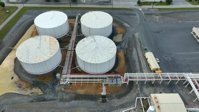 Tilt up aerial reveal of fuel storage terminal. Bulk tanks for oil gas and home heating oil in USA.