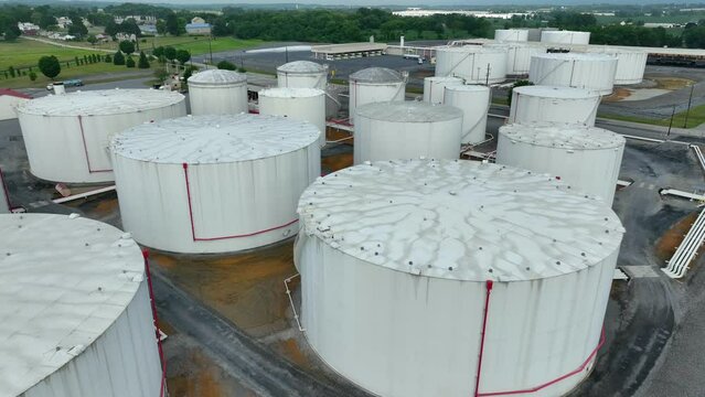 Rising aerial reveal of fuel storage tanks. Bulk gasoline diesel and home heating oil terminal.