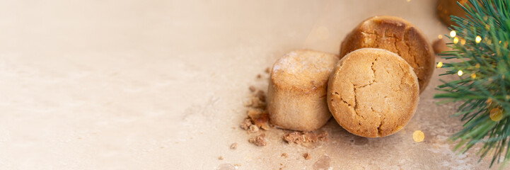Traditional Spanish sweet Mantecados, soft shortbread with fir tree bunch and bokeh. Christmas sweet . Banner