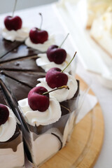Chocolate Whipped Cream Cake with fresh cherry on the table. Homemade bakery concept