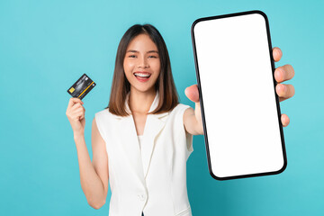 Studio shot of Beautiful Asian woman holding smartphone mockup of blank screen and show credit card...